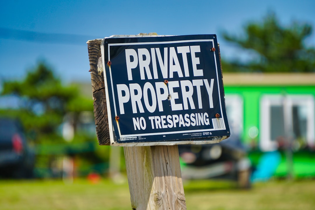 a private property sign posted on a wooden post