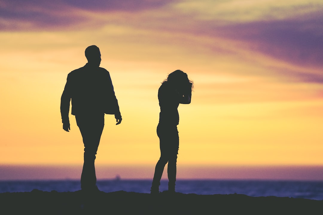 Photo by Eric Ward silhouette of man and woman under yellow sky