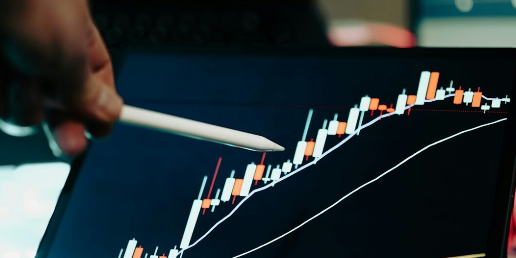Photo by Jakub Żerdzicki A person pointing at a chart on a laptop