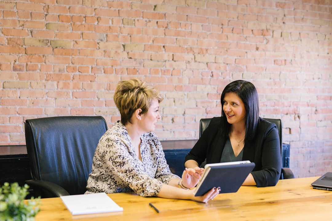 Photo by Amy Hirschi two women sitting on leather chairs in front of table