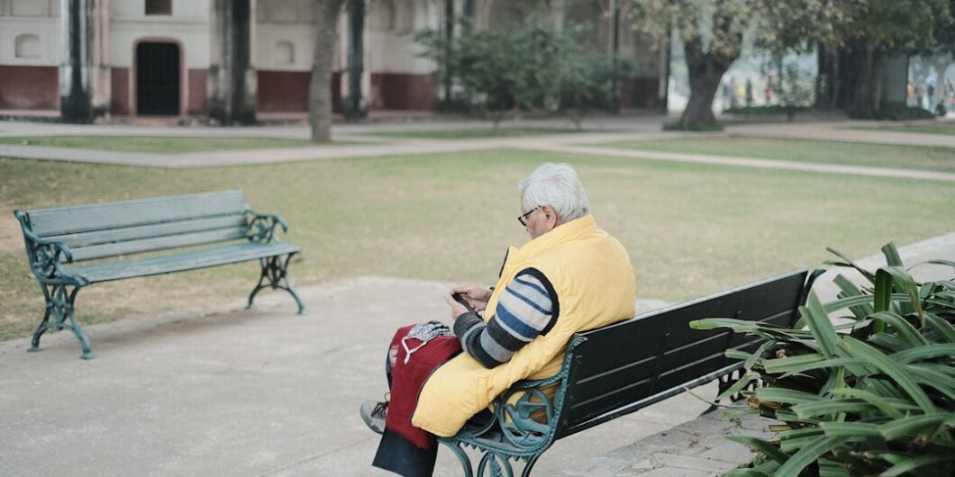 a man sitting on a bench in a park