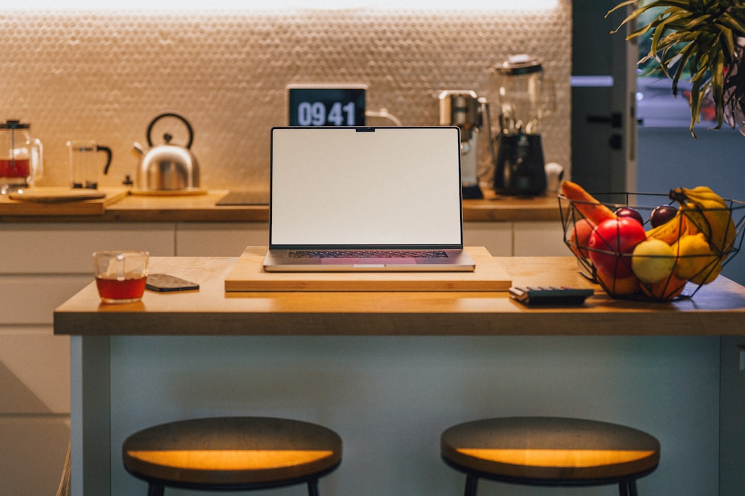 A laptop computer sitting on top of a kitchen counter