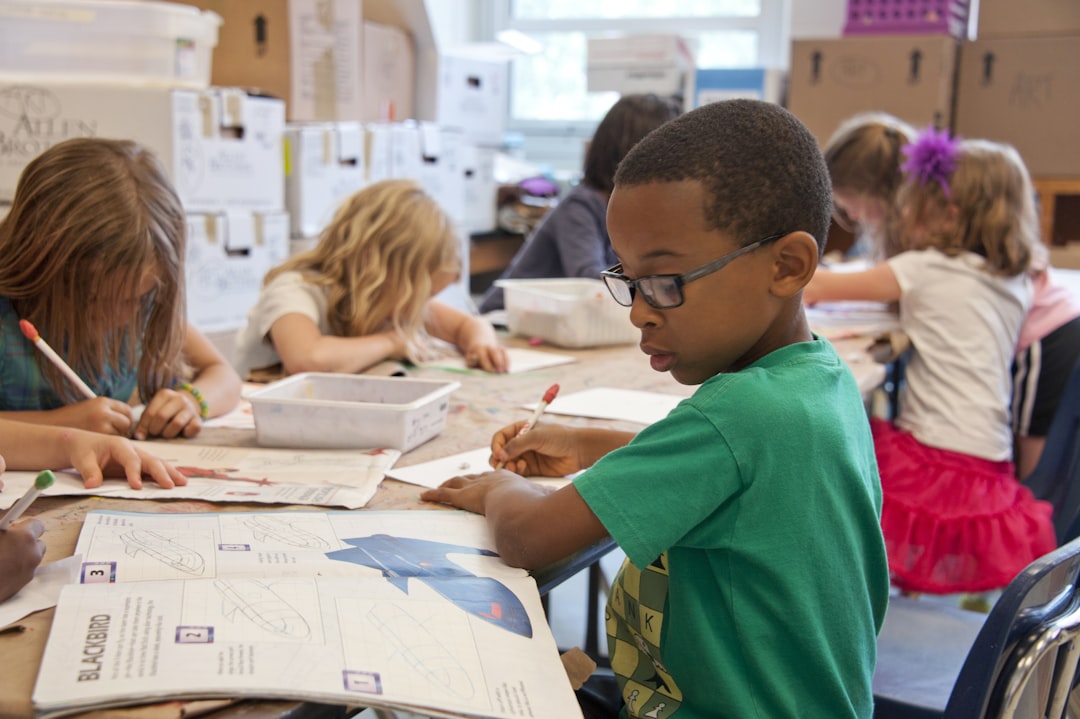 Photo by CDC boy in green sweater writing on white paper