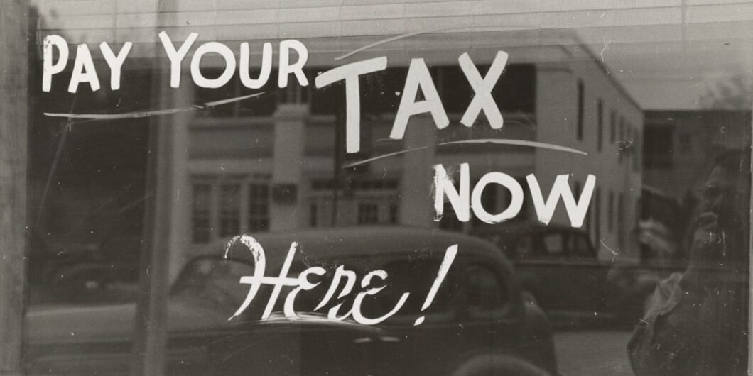 Photo by The New York Public Library a sign that says pay your tax now here