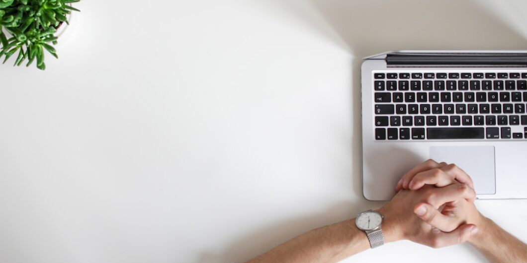 person wearing watch near laptop
