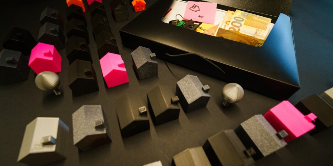 Miniature houses arranged with cash in an open box.