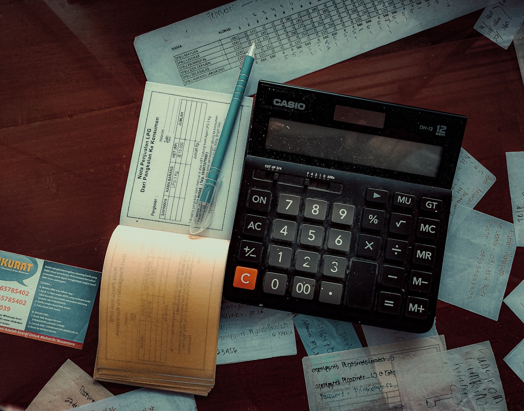 Photo by FIN a calculator sitting on top of a wooden table