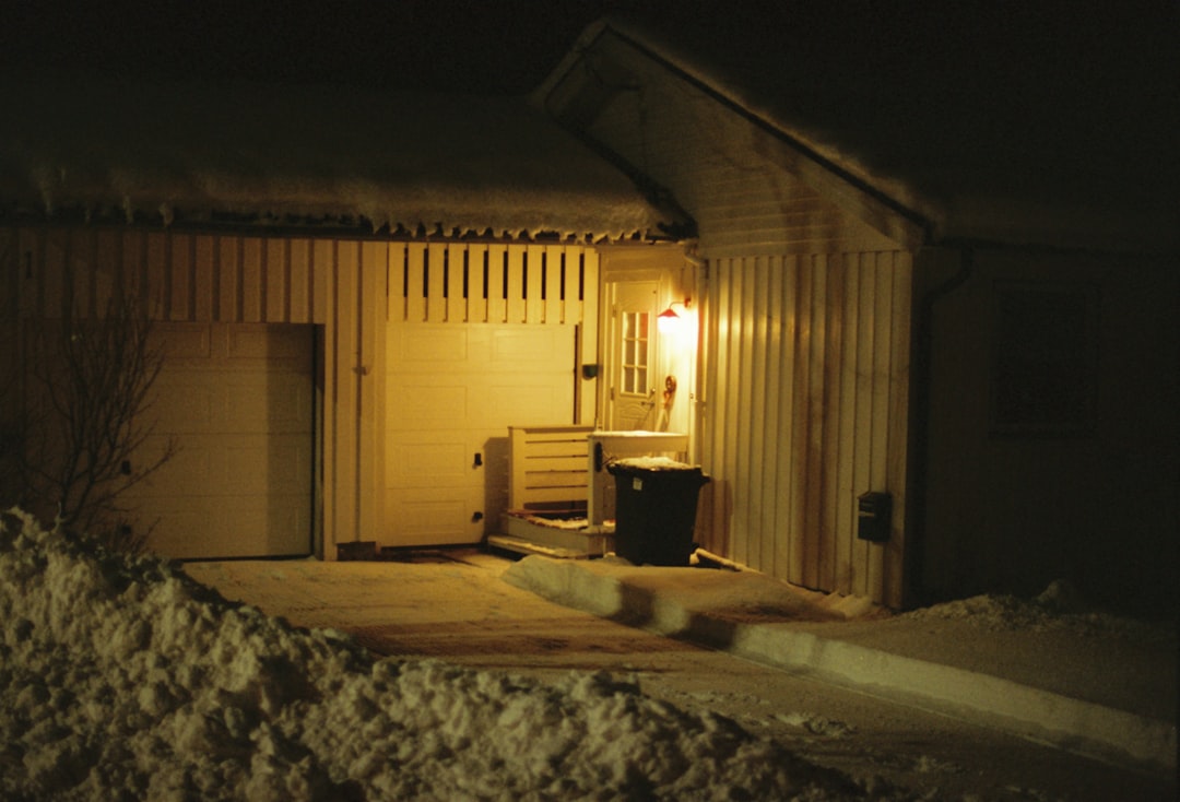 A house with a door at night in the snow.
