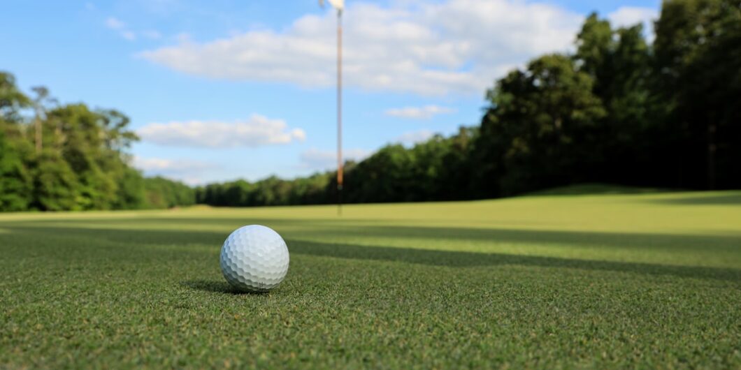 a golf ball sitting on top of a green field