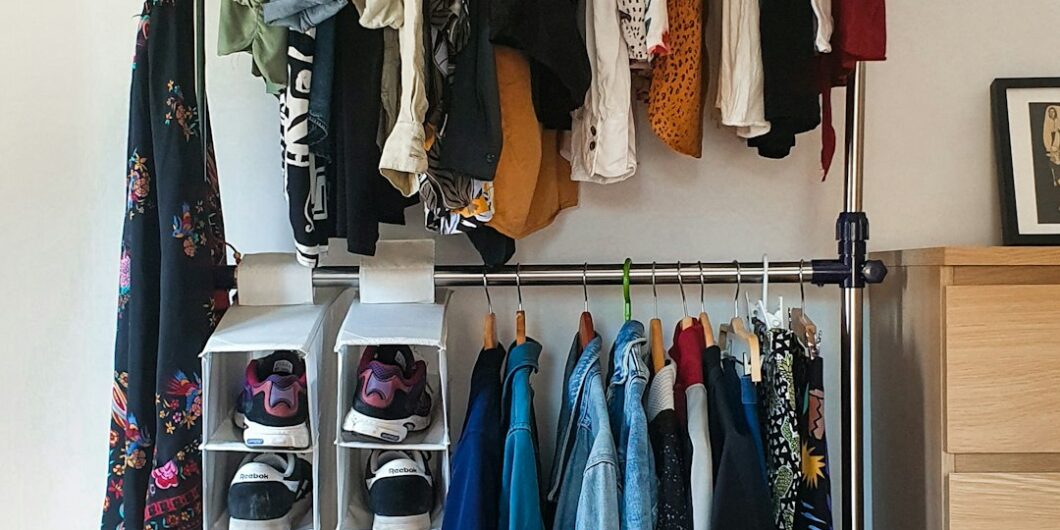 clothes hanged on brown wooden cabinet