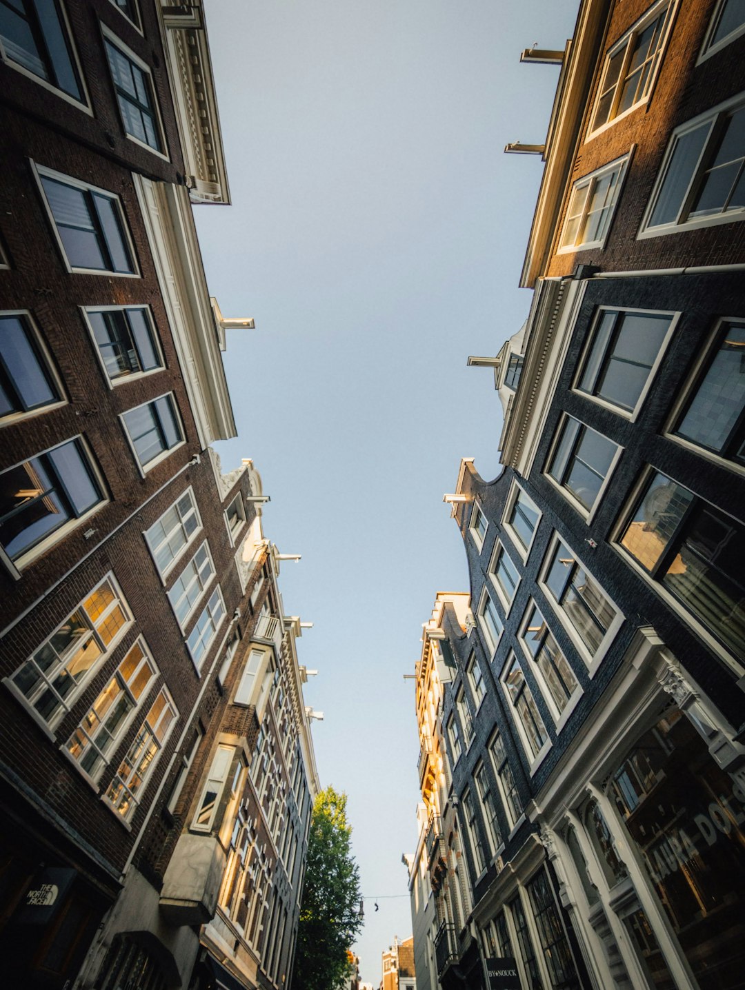Photo by Chris Weiher Tall, narrow buildings line a street under a clear sky.